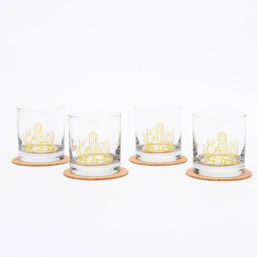 Four glass tumblers with cactus designs on coasters against a white background