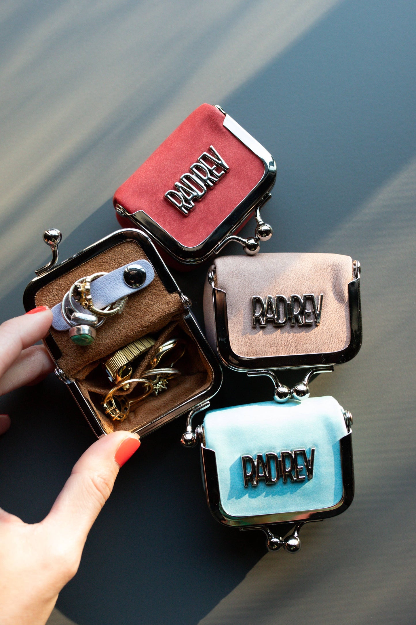Set of small, decorative purses with 'RADER' branding on a dark background.