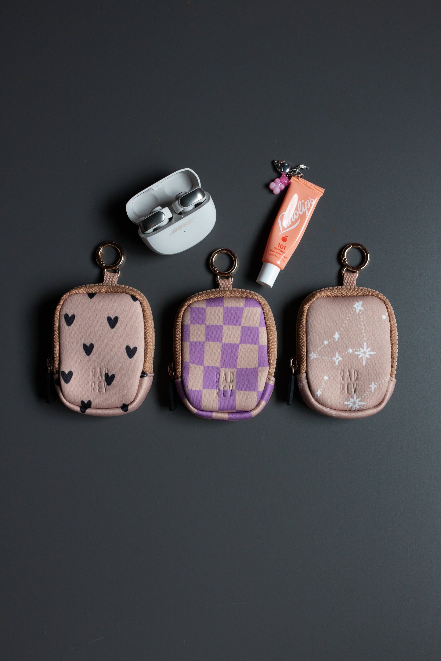 Three small fabric pouches with different patterns on a dark background