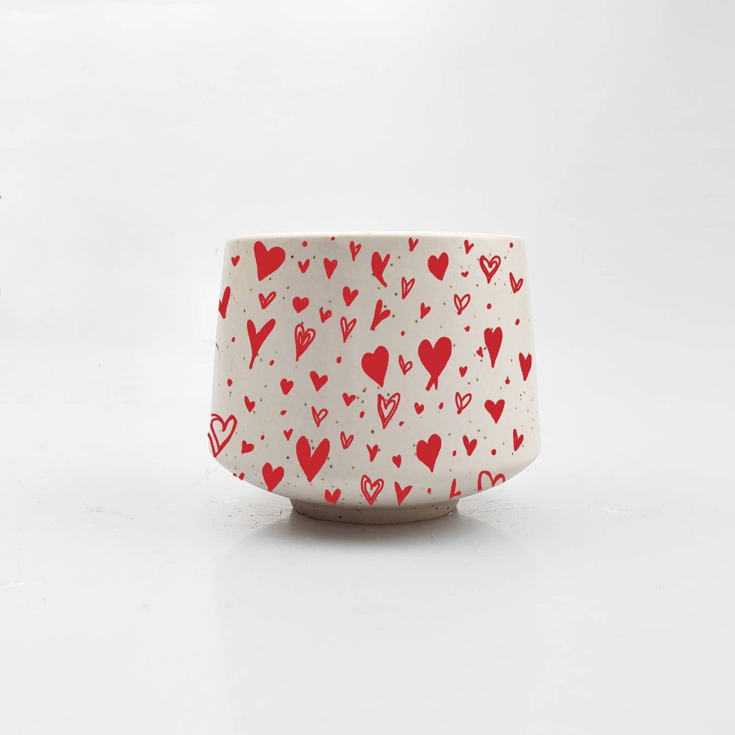 Ceramic cup with red heart pattern on a white background