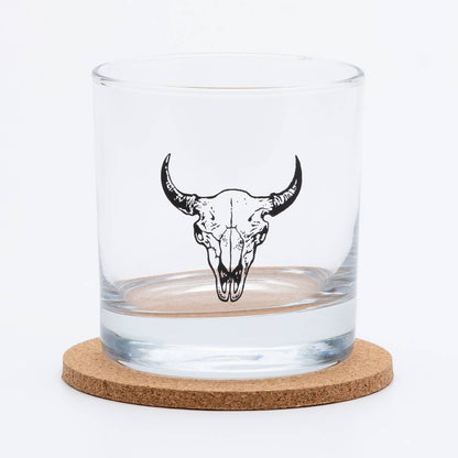 Clear glass tumbler with bull skull design on a cork coaster