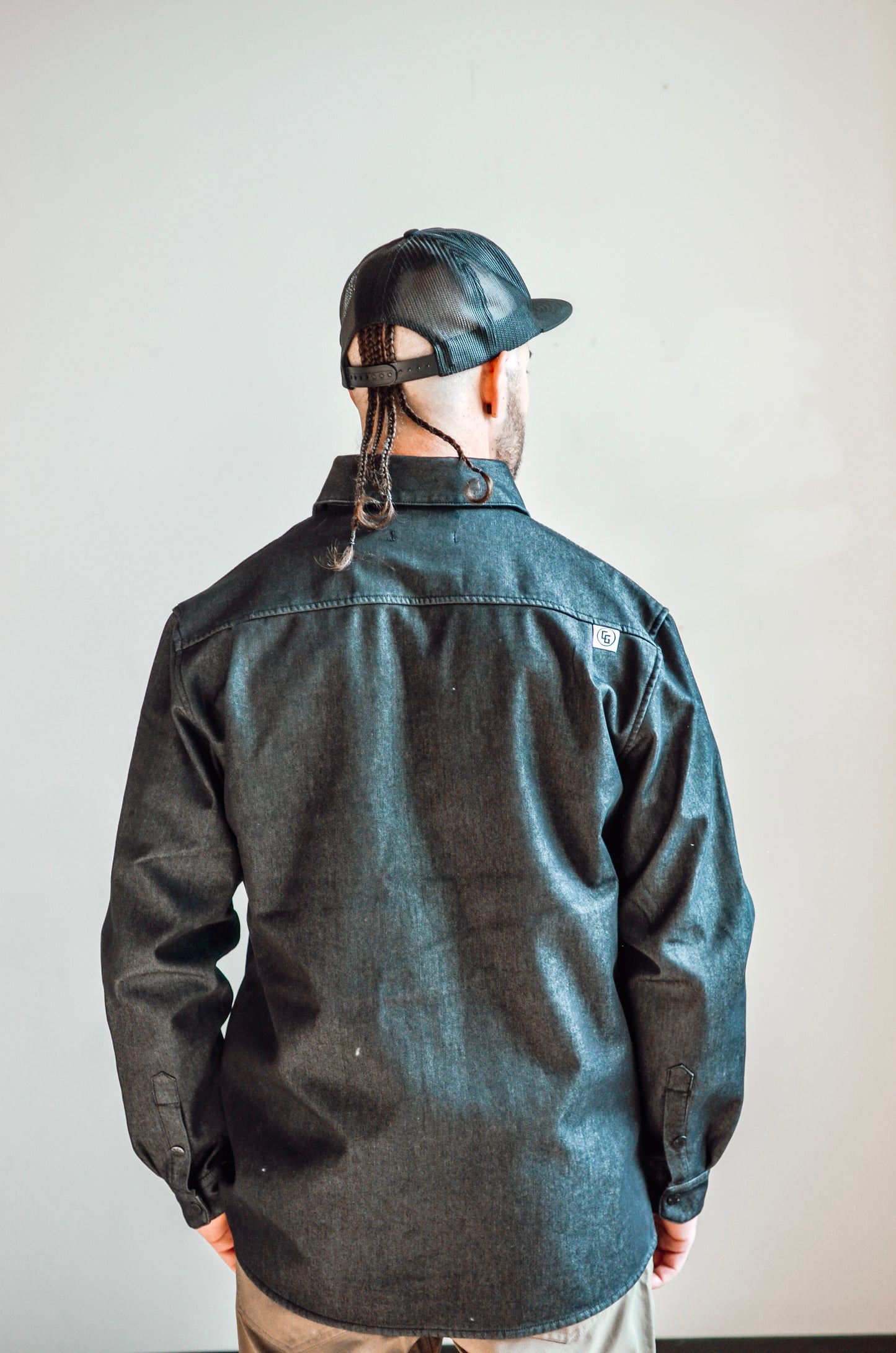 Person wearing a dark jacket and helmet against a plain background