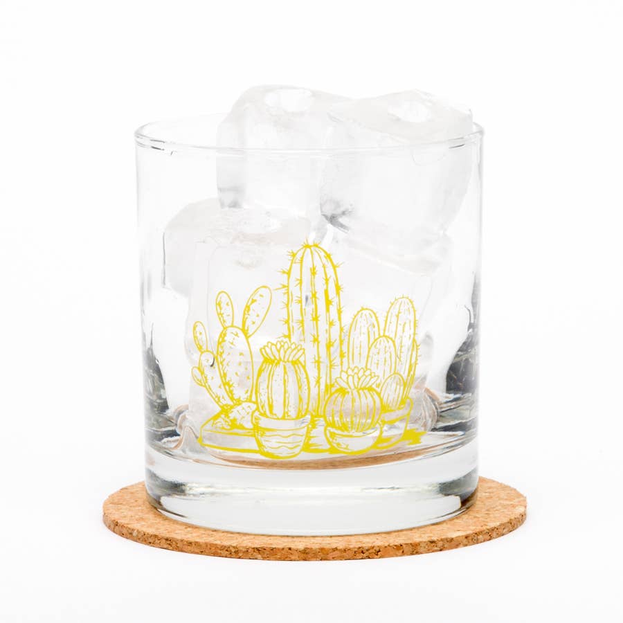 Clear glass tumbler with yellow cactus design on a cork coaster