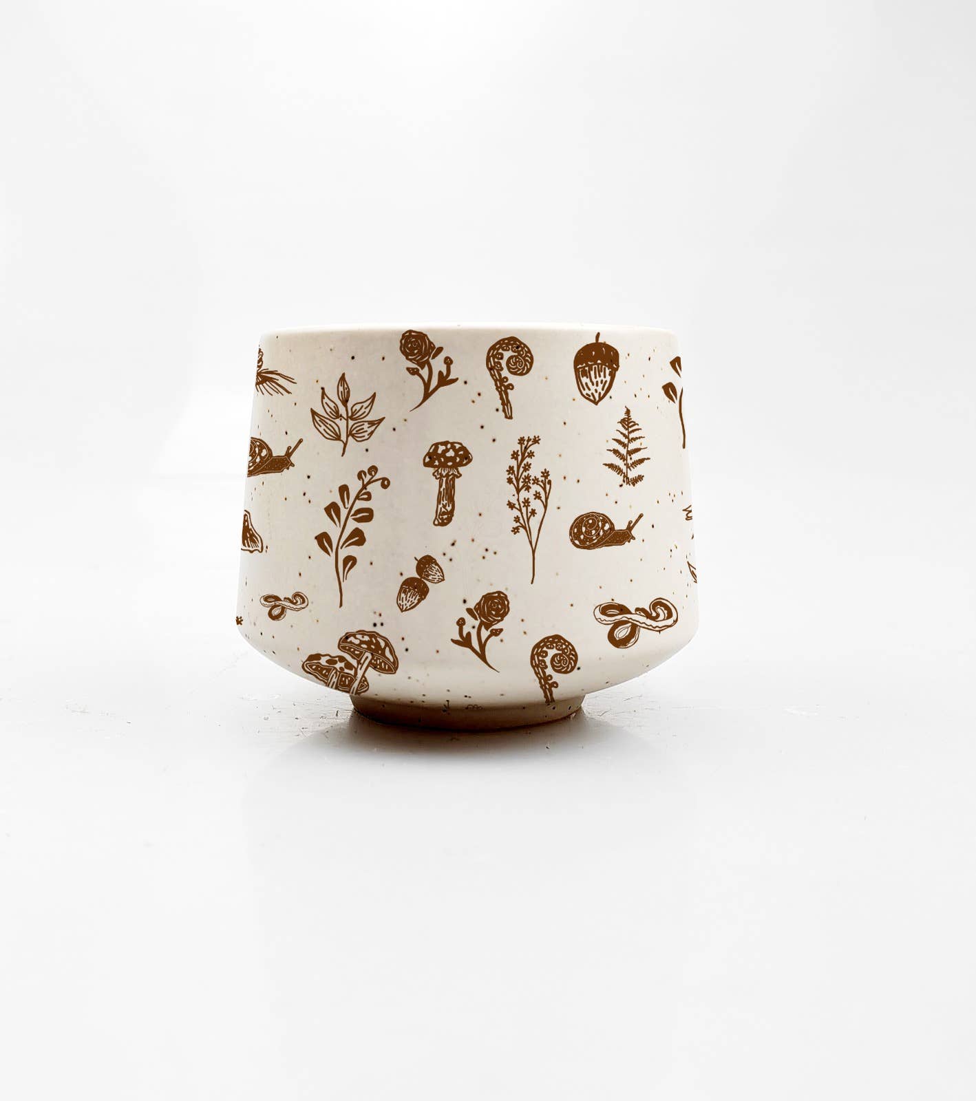 Ceramic cup with brown botanical patterns on a white background