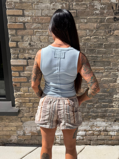 Person standing on a stone pavement with a brick wall background