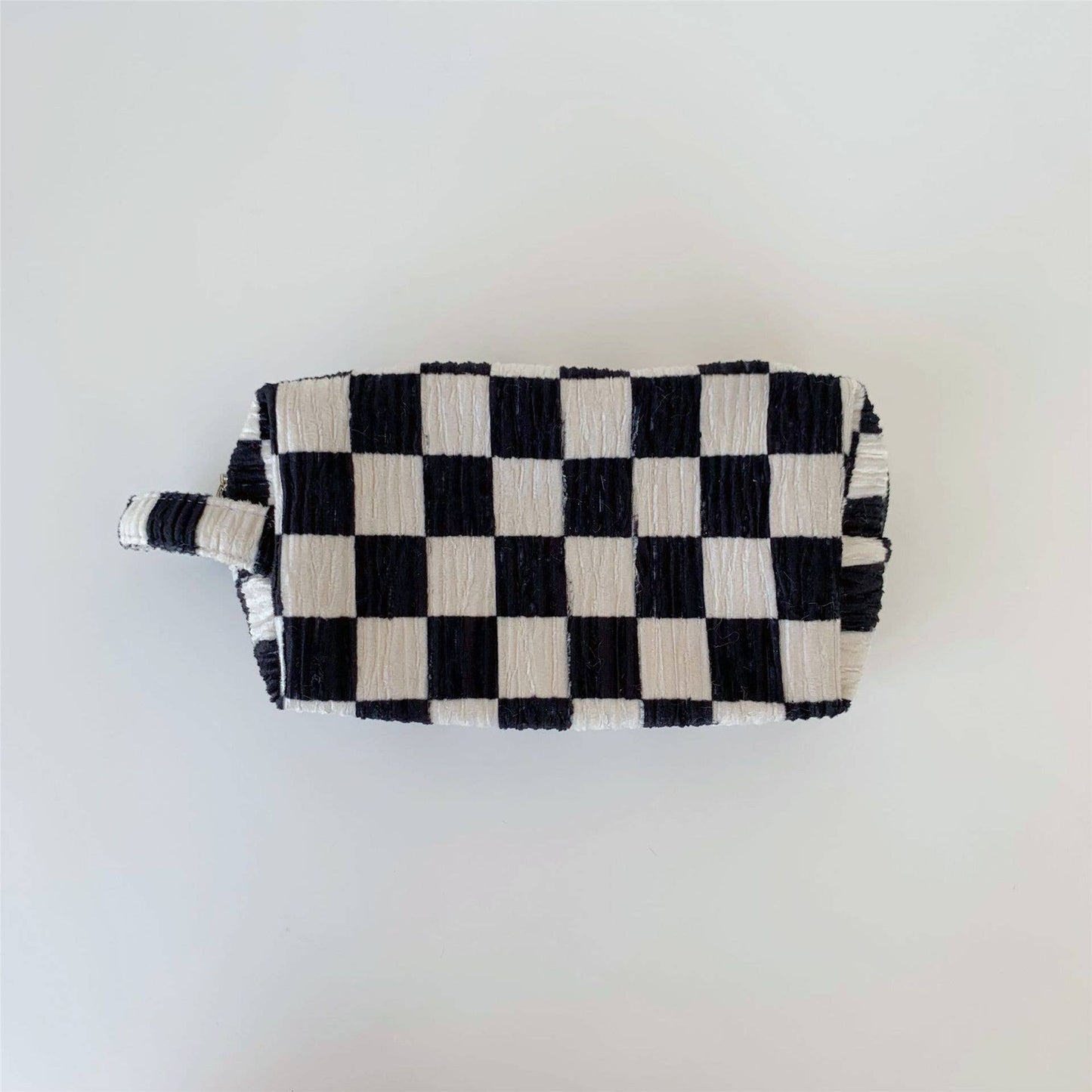 Black and white checkered pouch on a light gray background