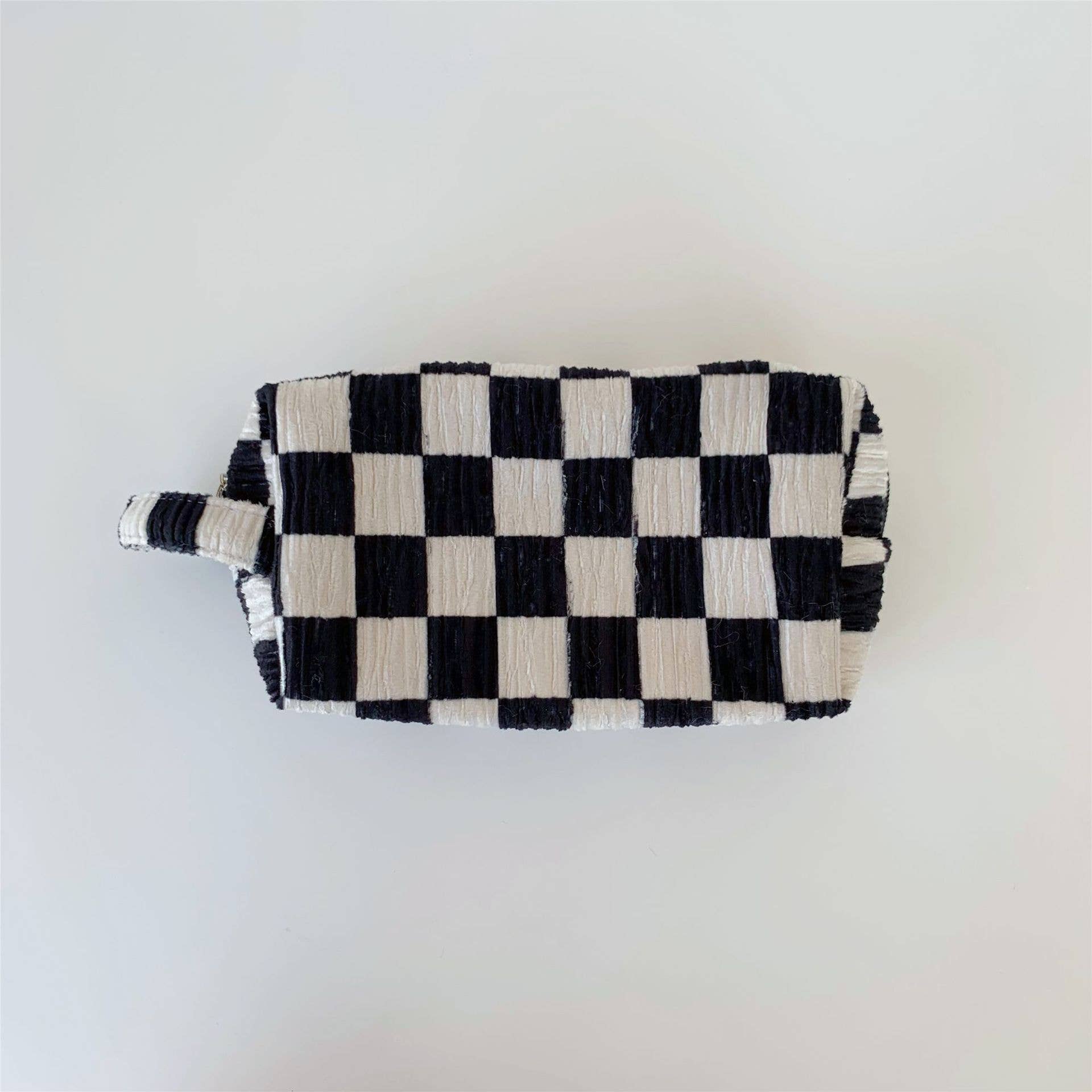 Black and white checkered pouch on a light gray background