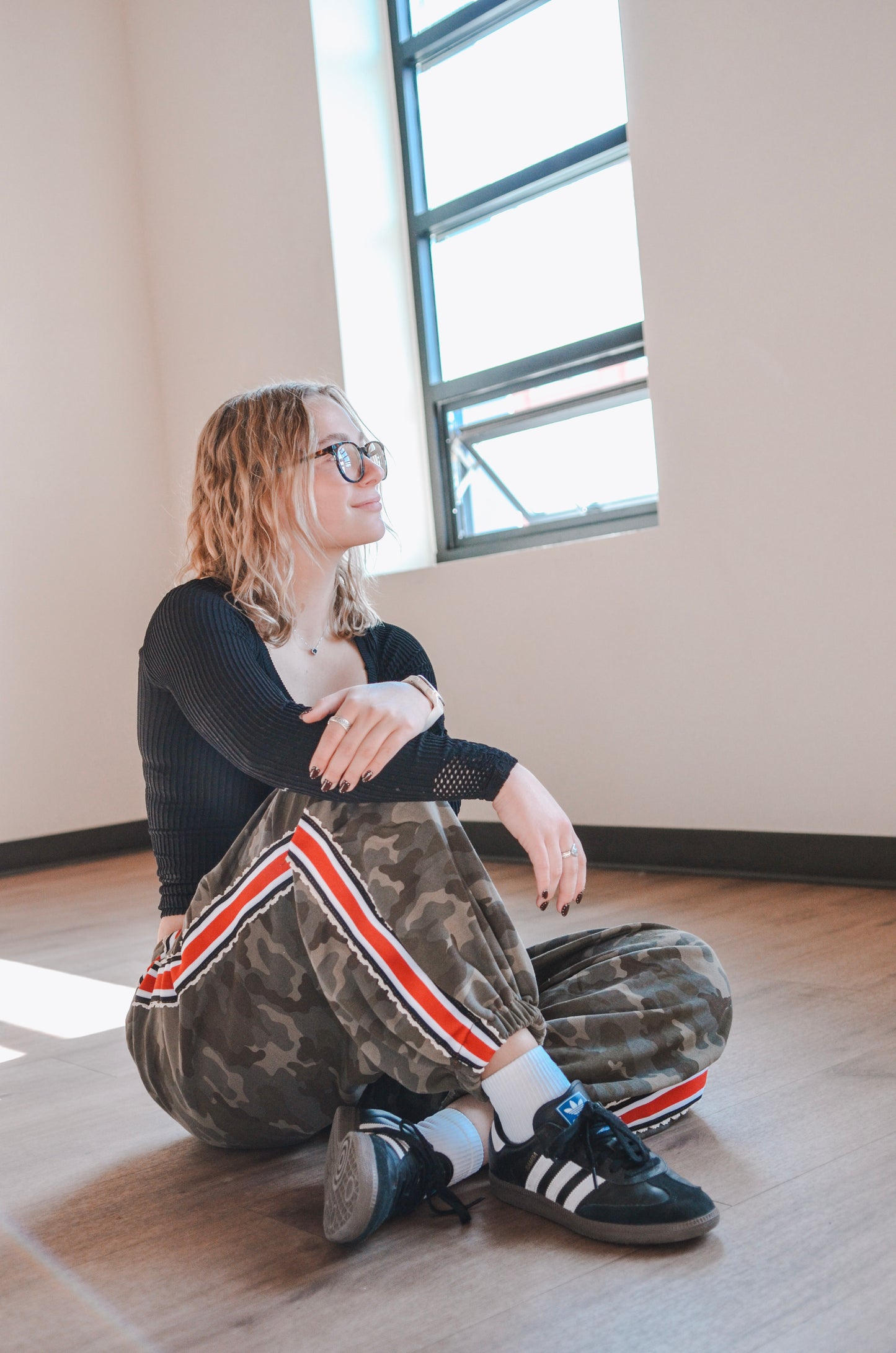 Person sitting on the floor in a room with large windows