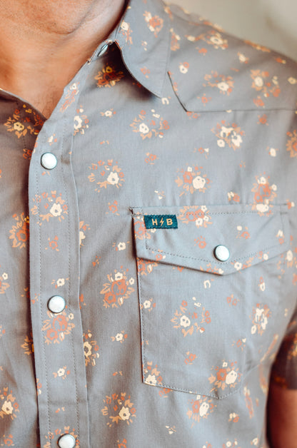 Floral patterned shirt with a brand label on a neutral background