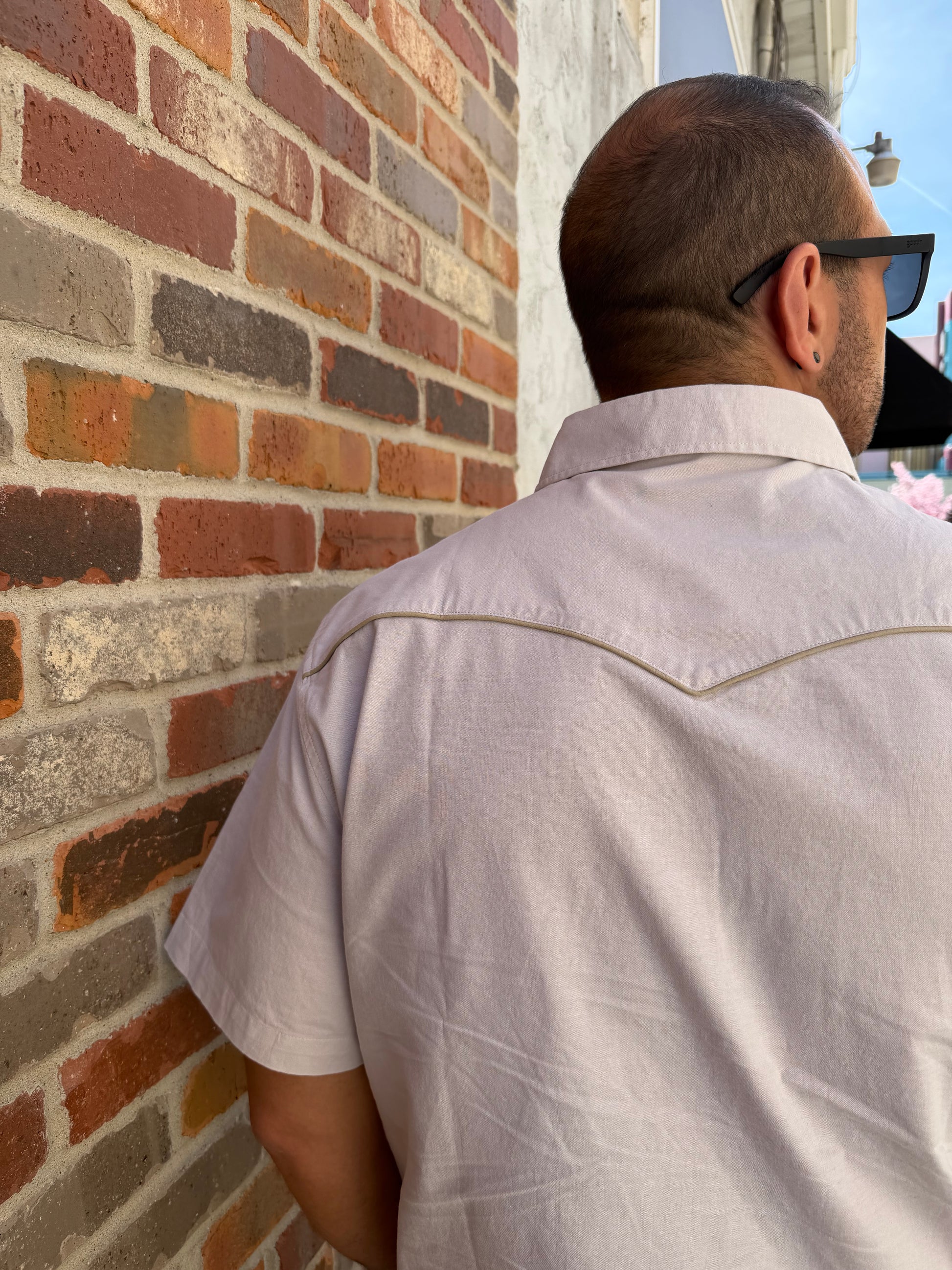 Person wearing a white shirt on a brick pavement