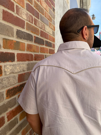 Person wearing a white shirt on a brick pavement