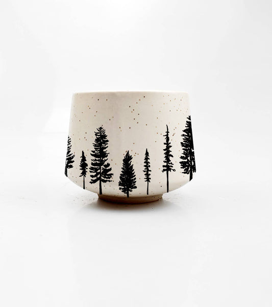 Ceramic cup with black tree pattern on a white background