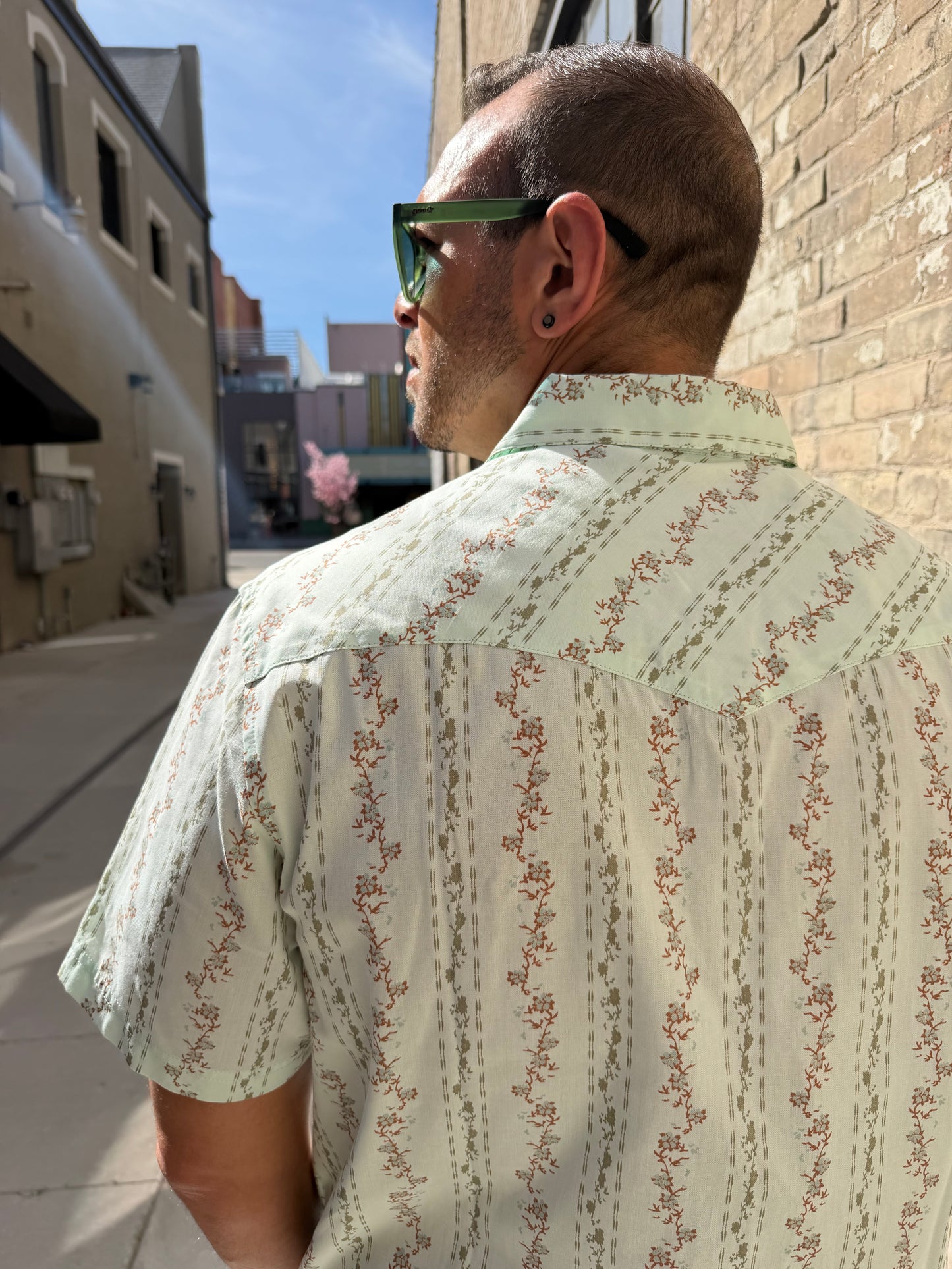 Person wearing a patterned shirt with a blurred background