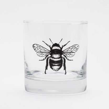 Clear glass tumbler with a black bee illustration on a white background