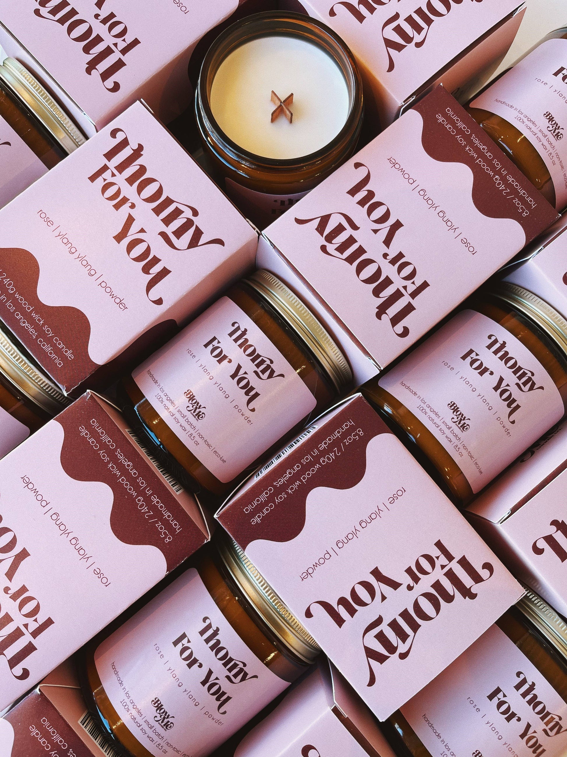 Jars and boxes of 'Thorny For You' products with candles on a patterned background.