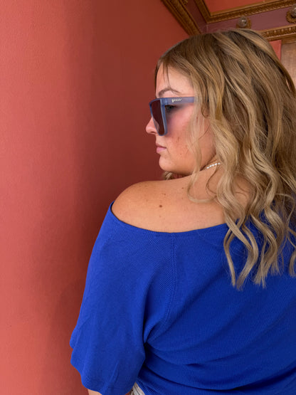 Person wearing a blue top with a blurred background