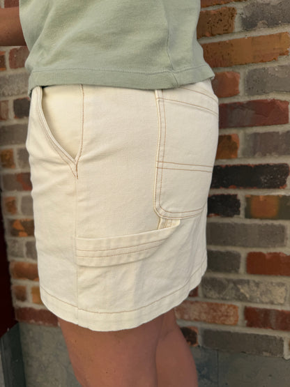 Close-up of light-colored shorts against a brick wall.