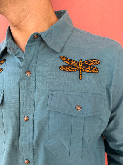 Blue jacket with a dragonfly patch on a pink background