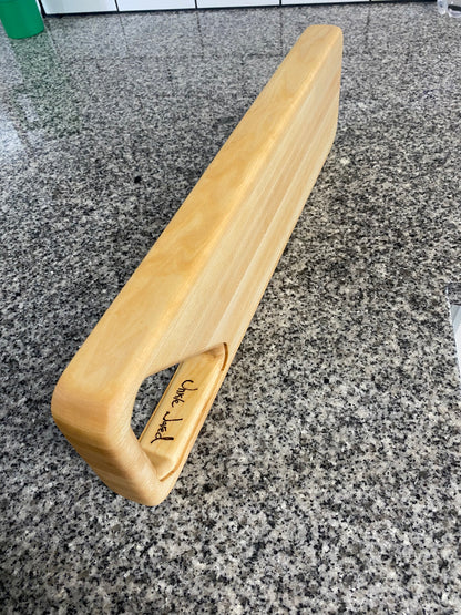 Wooden handle with 'Unkle Jared" engraving on a gray stone surface