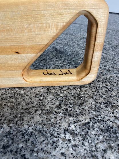 Wooden cutting board with a handle on a granite countertop