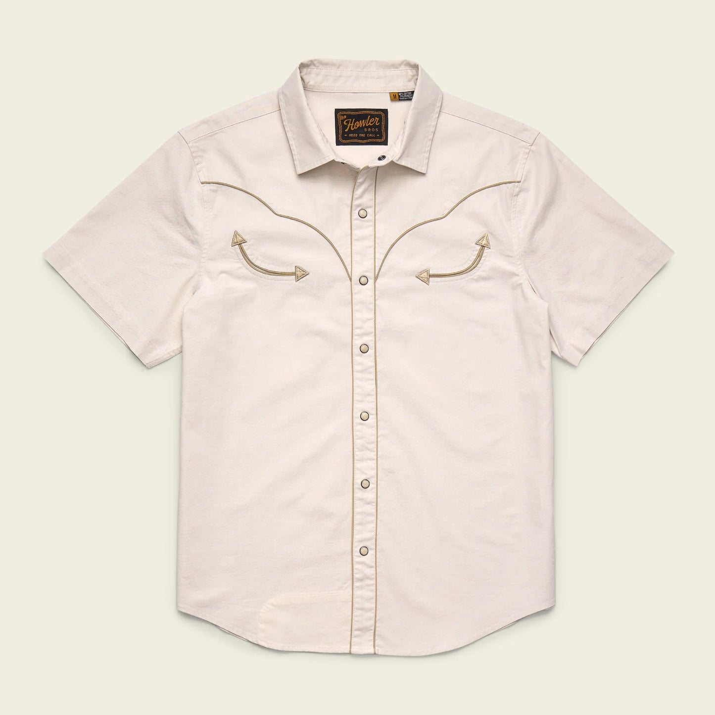 Light pink short-sleeve shirt with embroidered details on a beige background