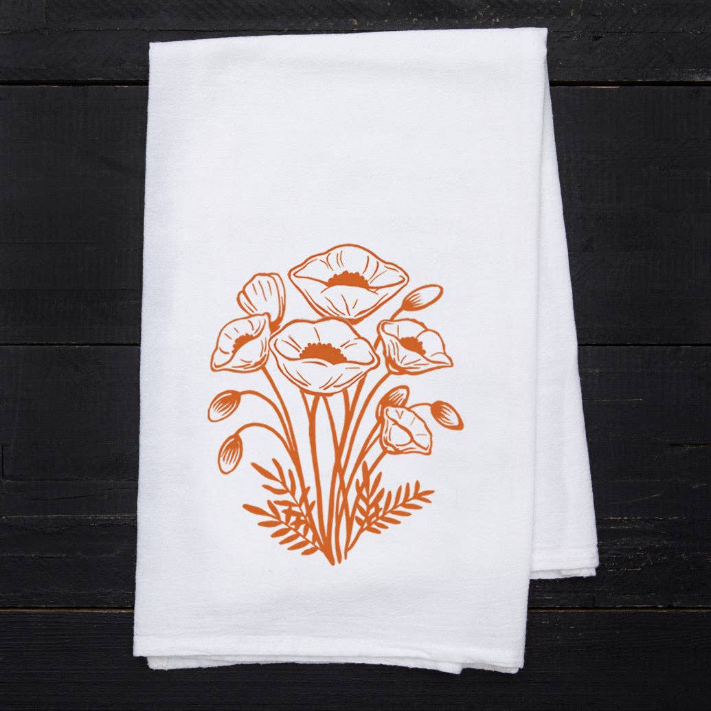 White towel with orange floral design on a black wooden surface