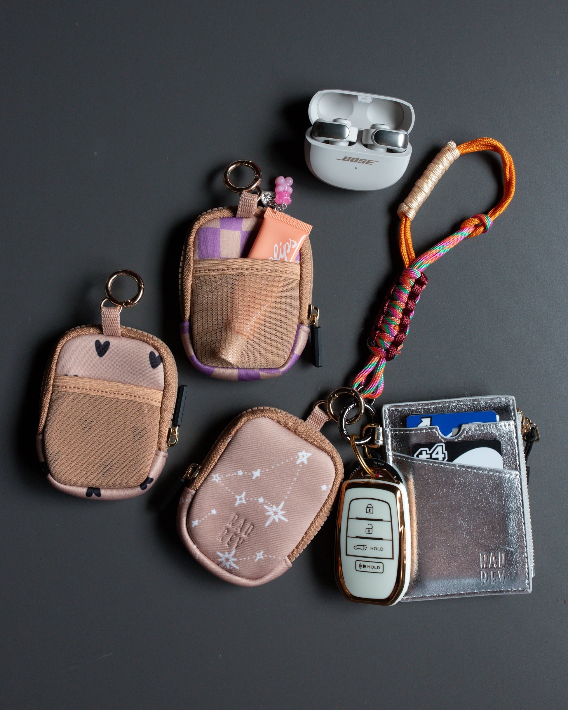 Collection of small pouches, keychains, and a card holder on a dark surface