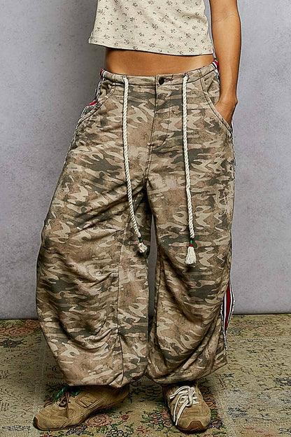 Person wearing camouflage pants with a plain background