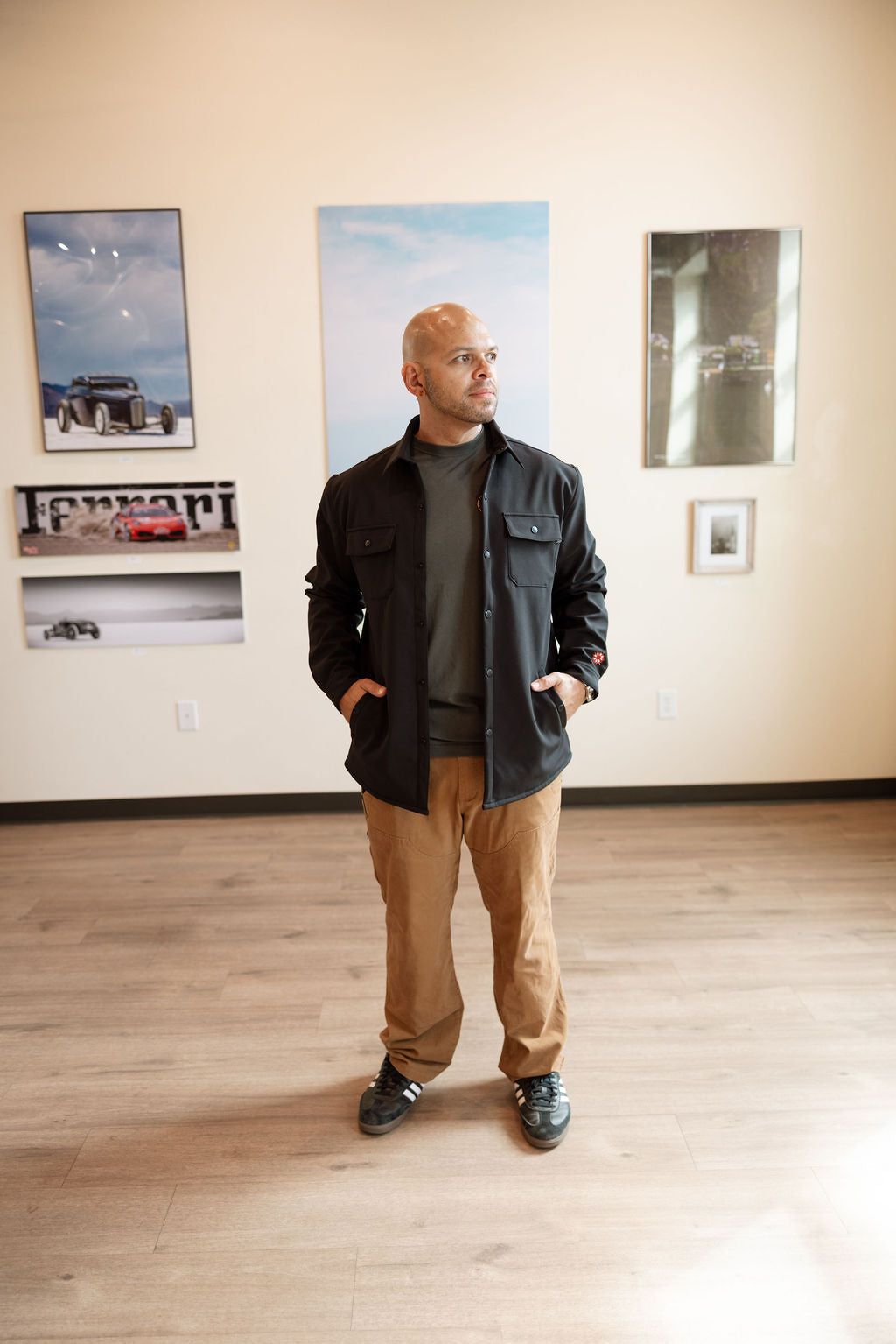 Man standing in a room with framed pictures on the wall