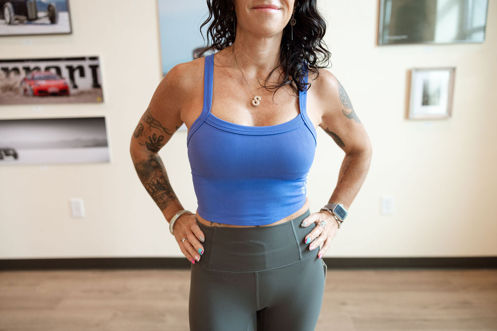 woman smiling wearing blue top and gray bottoms